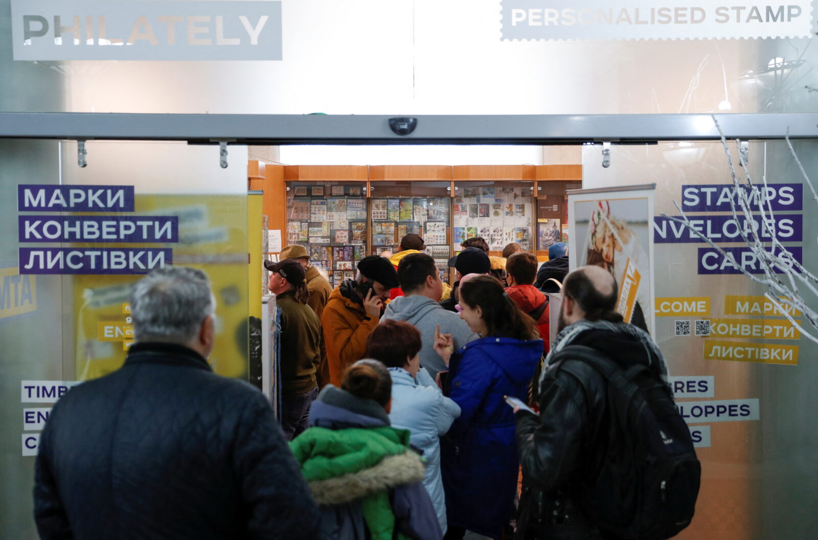 People stand in line to buy postal stamps showing Ukrainian service member and Russian warship, at the headquarters of Ukrainian post in Kyiv